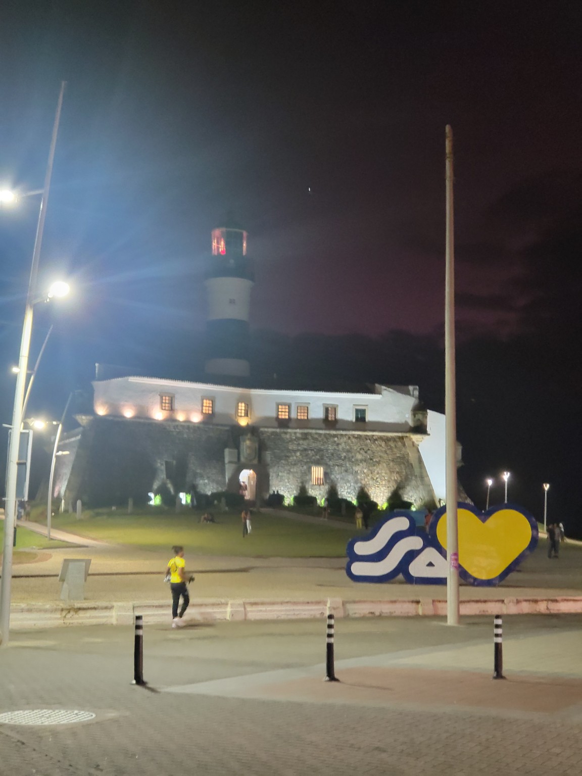 Historic fort and lighthouse illuminated at night in Salvador